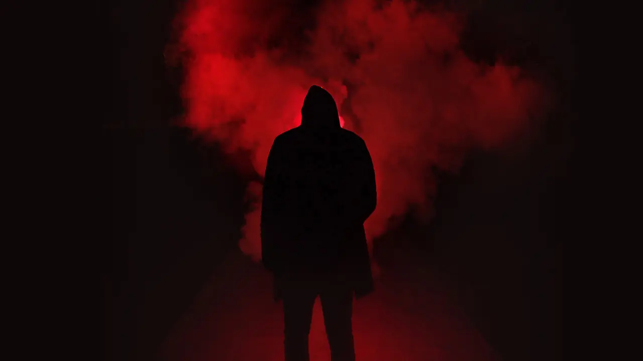 Silhouette - a person standing in a plume of red smoke.