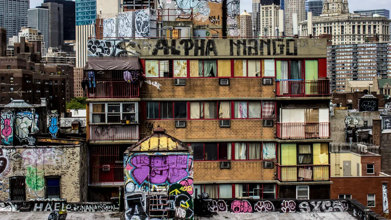 A building covered with graffiti adjacent to the Manhattan Bridge.